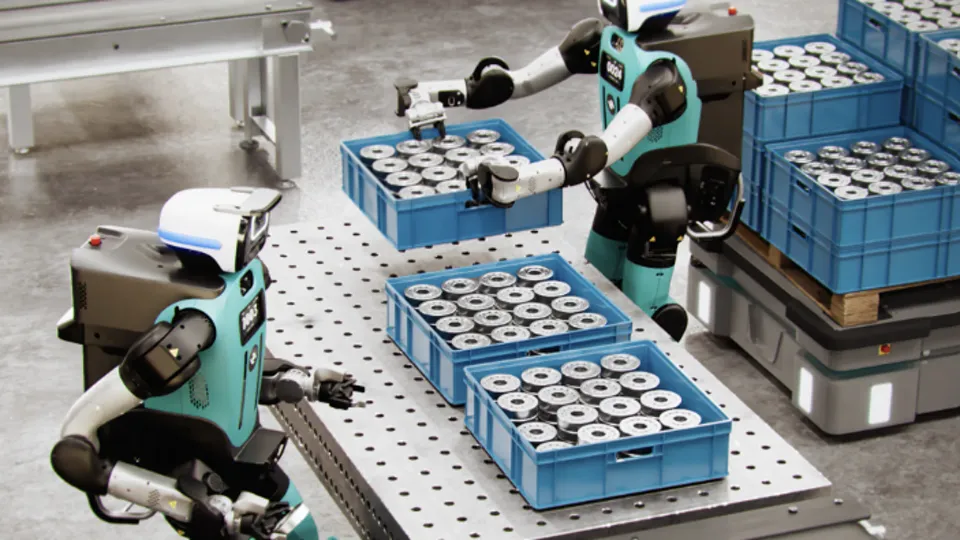 Two Agility Robotics Digit humanoids moving crates of parts in a warehouse