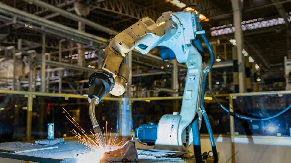 A welding robot arm throwing sparks on a factory line